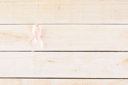Womens health symbol in pink ribbon on wooden board.の写真素材