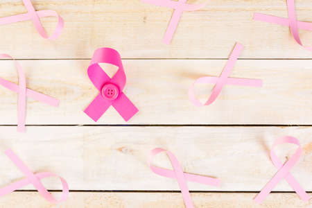 Womens health symbol in pink ribbon on wooden board.の写真素材
