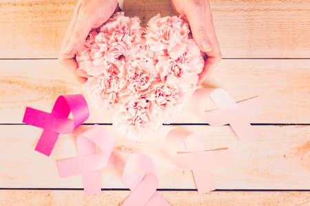 Womens health symbol in pink ribbon on wooden board.の写真素材