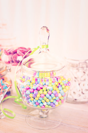 Multicolored candies in glass candy jars.