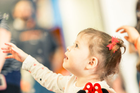 Cute toddler girl playing on indoor playground.