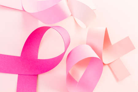 Womens health symbol in pink ribbon on a pink background.の写真素材