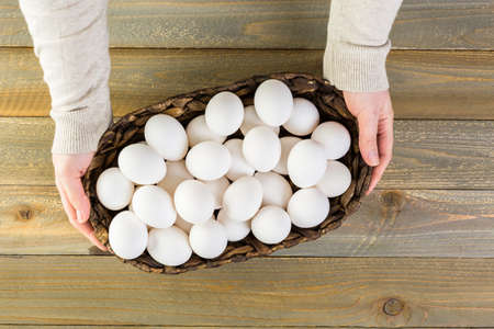 Farm fresh eggs in wicker basket on the table.の写真素材