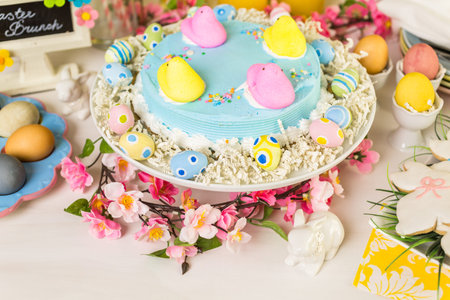 Dessert table with Easter cake decorated with traditional Easter marshmallow chicks.