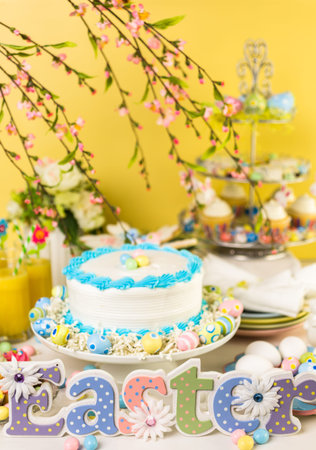 Dessert table set with cake and cupcakes for Easter brunch.