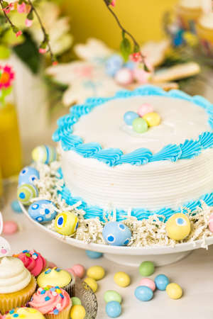 Dessert table set with cake and cupcakes for Easter brunch.の写真素材
