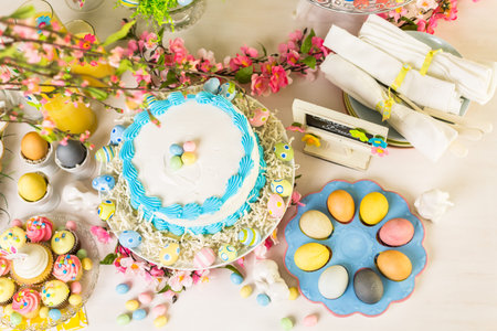 Dessert table set with cake and cupcakes for Easter brunch.