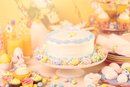 Dessert table set with cake and cupcakes for Easter brunch.