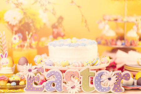 Dessert table set with cake and cupcakes for Easter brunch.