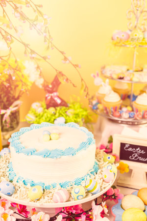 Dessert table set with cake and cupcakes for Easter brunch.