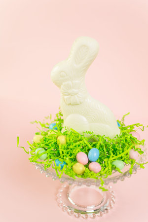 Chocolate Easter bynny with chocolate Easter candies on stand.