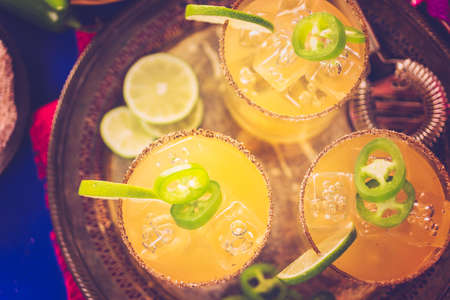 Spicy grapefruit margarita cocktail garnished with lime and jalapenos.の写真素材