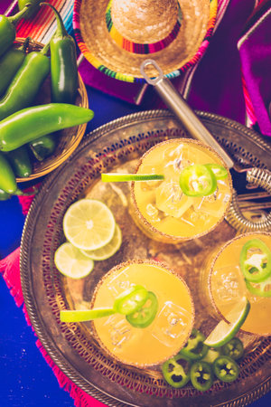 Spicy grapefruit margarita cocktail garnished with lime and jalapenos.