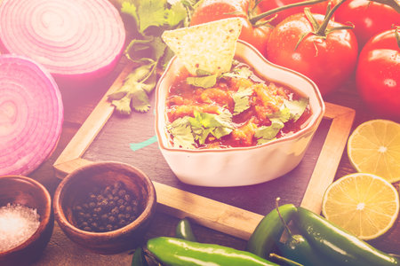 Fresh salsa in white bowl with ingredients.の写真素材