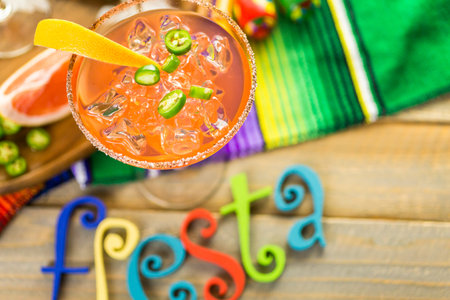 Spicy grapefruit margarita on ice in margarita glass.