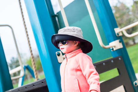 Toddler on toddler playground in urban park.の写真素材