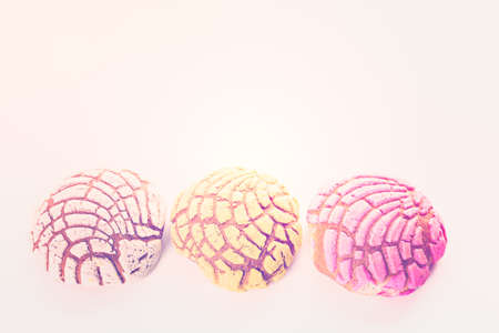 Homemade pan dulche with white, yellow, and pink icing.の写真素材