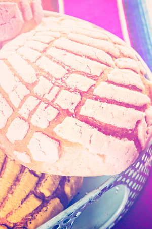 Homemade pan dulche with white, yellow, and pink icing.の写真素材