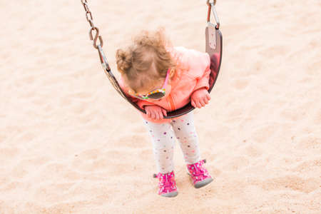Toddler playing at the playground in urban park.の写真素材