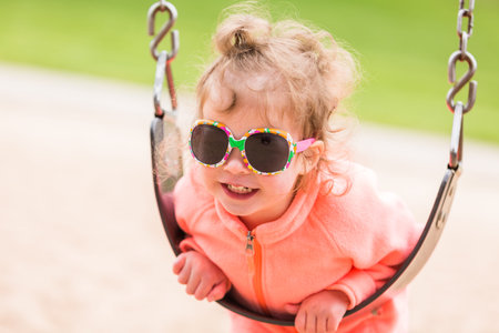 Toddler playing at the playground in urban park.
