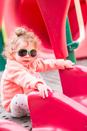 Toddler playing at the playground in urban park.の写真素材