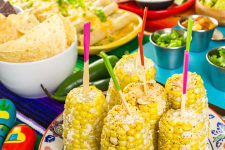 Fiesta party buffet table with spicy mexican corn on the cob and other traditional Mexican food.の写真素材