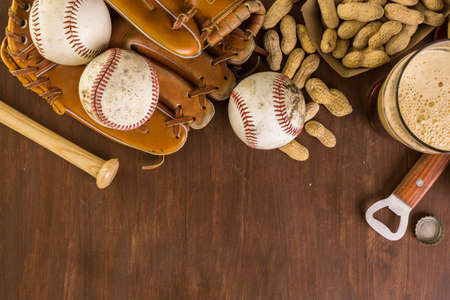 Close up of old worn baseball equipment on a wooden background.の写真素材