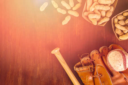 Close up of old worn baseball equipment on a wooden background.の写真素材