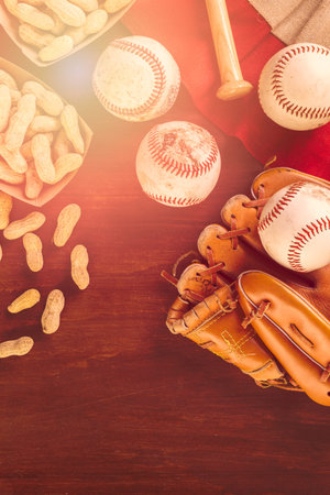 Close up of old worn baseball equipment on a wooden background.の写真素材