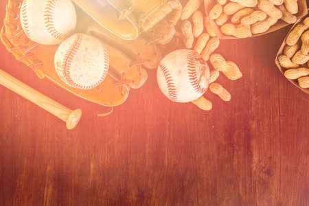 Close up of old worn baseball equipment on a wooden background.の写真素材