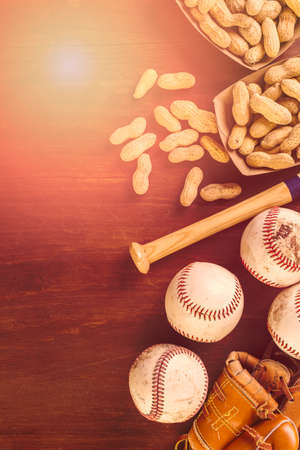 Close up of old worn baseball equipment on a wooden background.の写真素材