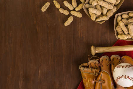 Close up of old worn baseball equipment on a wooden background.の写真素材