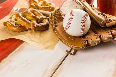 Close up of old worn baseball equipment on a wooden background.の写真素材