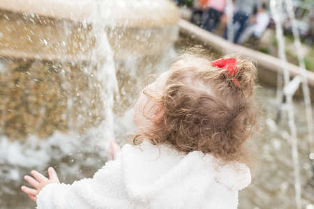 Toddler playing at large fountain in the park.の写真素材