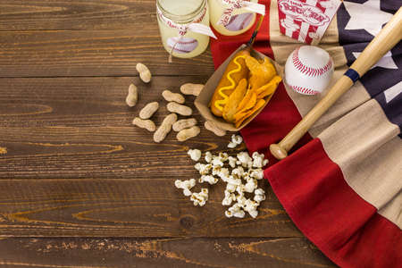 Game day traditional snacks included corndogs and salted peanuts on a wood board.の写真素材