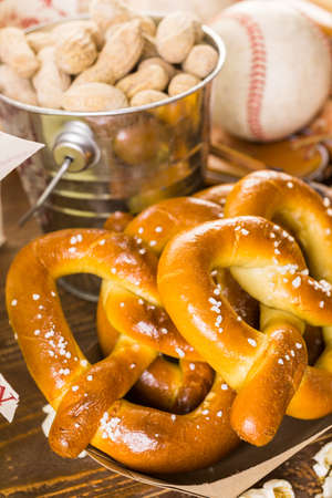 Game day traditional snacks included corndogs and salted peanuts on a wood board.の写真素材