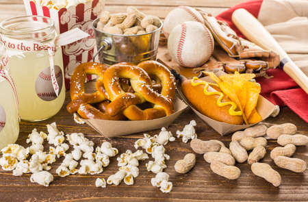 Game day traditional snacks included corndogs and salted peanuts on a wood board.の写真素材