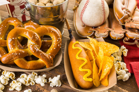 Game day traditional snacks included corndogs and salted peanuts on a wood board.の写真素材
