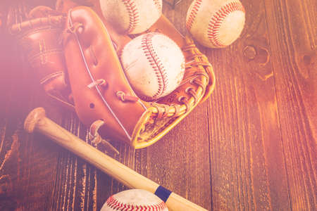 Baseball ball and glove on a wood board.の写真素材