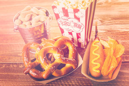 Game day traditional snacks included corndogs and salted peanuts on a wood board.の写真素材