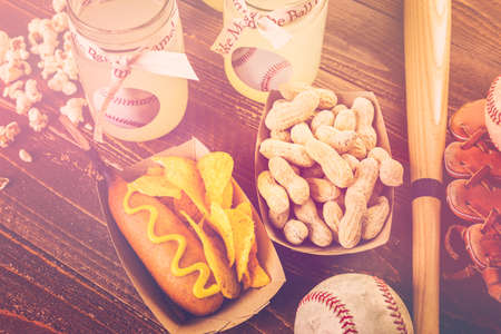 Game day traditional snacks included corndogs and salted peanuts on a wood board.の写真素材