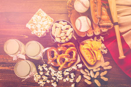 Game day traditional snacks included corndogs and salted peanuts on a wood board.の写真素材