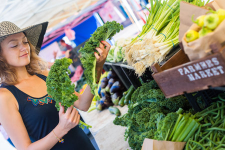 Young woman shopping at the local Farmers market.の写真素材