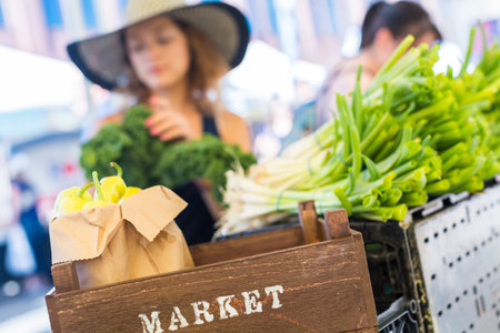 Young woman shopping at the local Farmers market.の写真素材