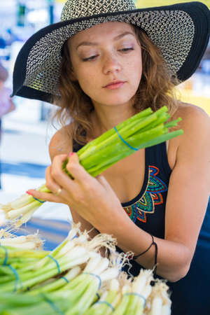Young woman shopping at the local Farmers market.の写真素材