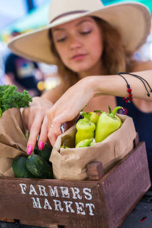 Young woman shopping at the local Farmers market.の写真素材