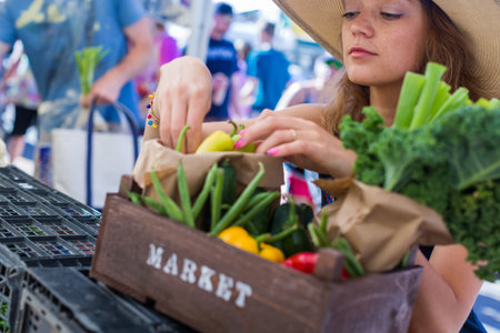 Young woman shopping at the local Farmers market.の写真素材