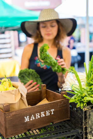 Young woman shopping at the local Farmers market.の写真素材
