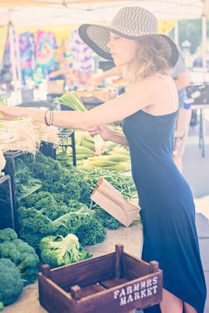 Young woman shopping at the local Farmers market.の写真素材