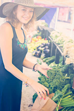 Young woman shopping at the local Farmers market.の写真素材